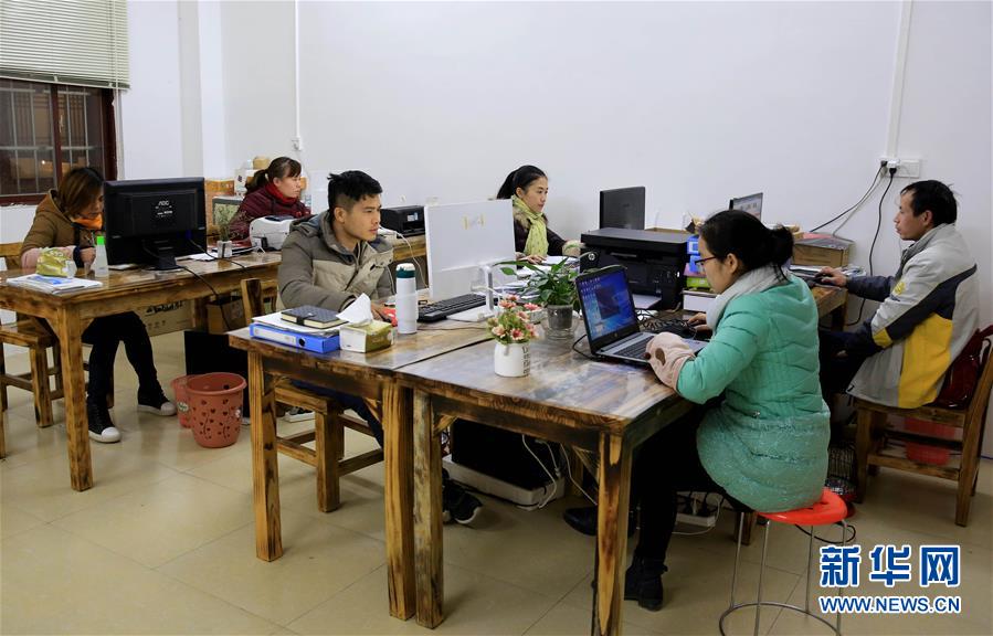 2月5日,在广西柳州市融水苗族自治县,石秋香(绿衣者)和员工一起加班.
