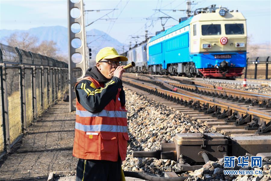 11月8日,火车临近,安全防护员提示现场作业的职工注意安全.