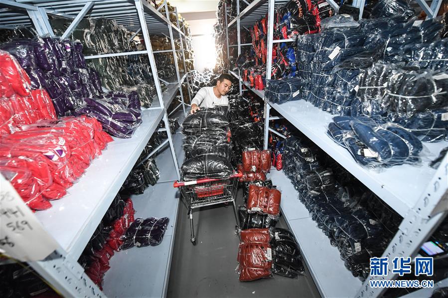 11月10日,织里镇一家童装企业的员工在仓库内给童装进行分类.