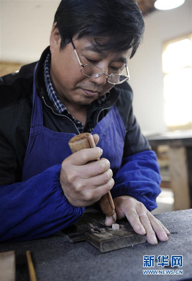 11月23日,雷石太在位于泾县琴溪镇旵山村的旵山古艺文化园刻木活字.