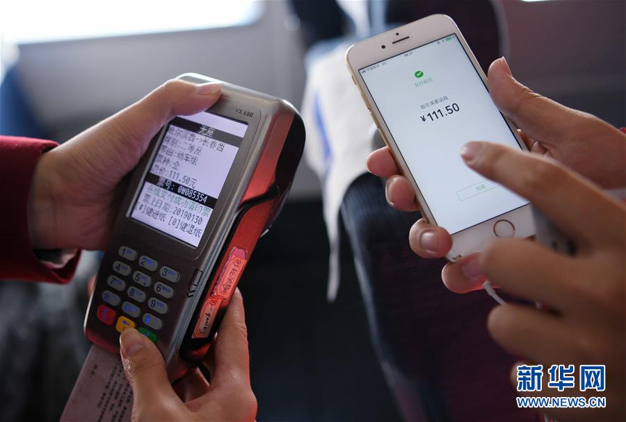 在g1206次高铁列车上,列车长张悦(左)为乘客办理补票(2019年1月30日摄