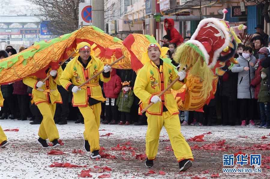 2月18日,社火队员在兰州市皋兰县县城街道表演舞龙.