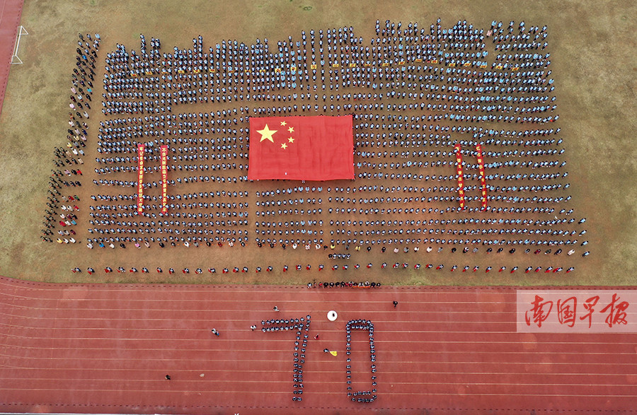 该校初一学生摆出"70"字样,学生方块中间托起一面大国旗