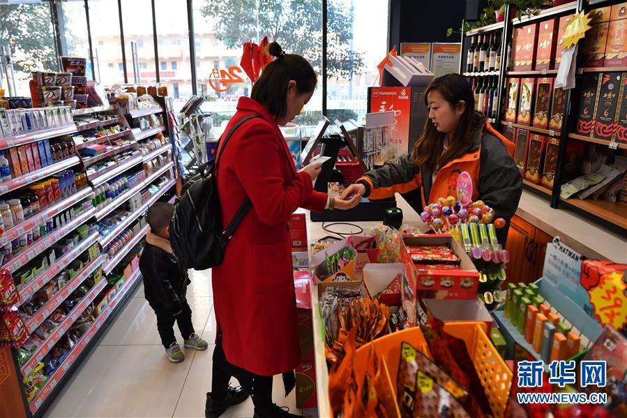 西安慧灵公益超市的店员小夕(右)在给顾客找零(12月2日摄).