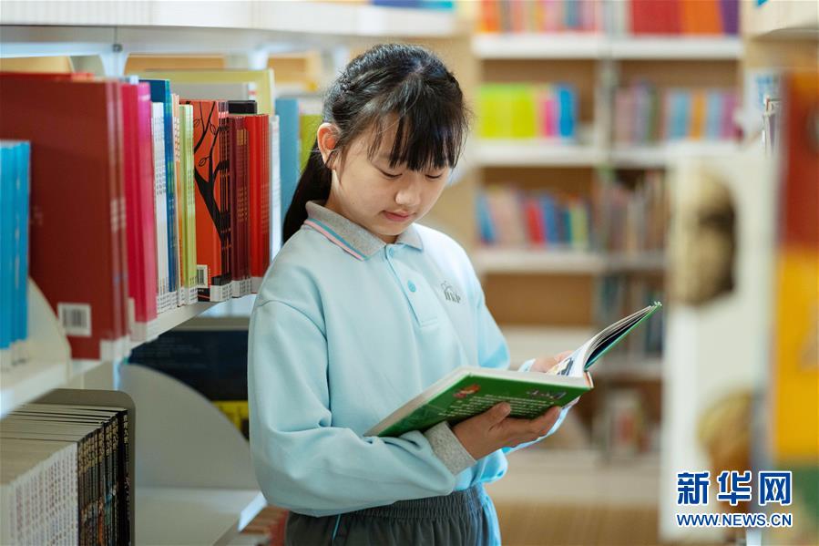 11月25日,喻彦茜在学校图书馆里看书.新华社记者 张金加 摄