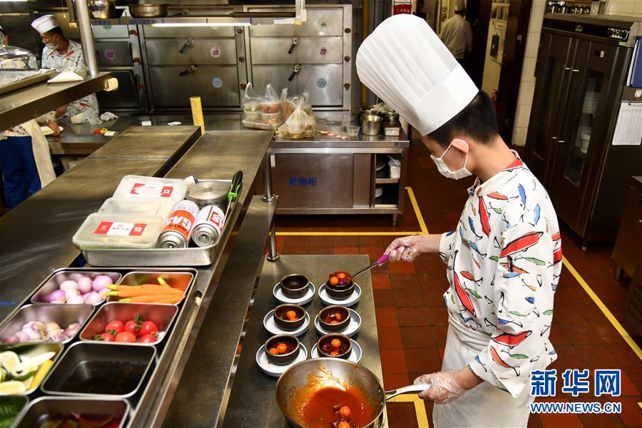 在山东舜和国际酒店,工作人员在为客人分餐(3月26日摄).
