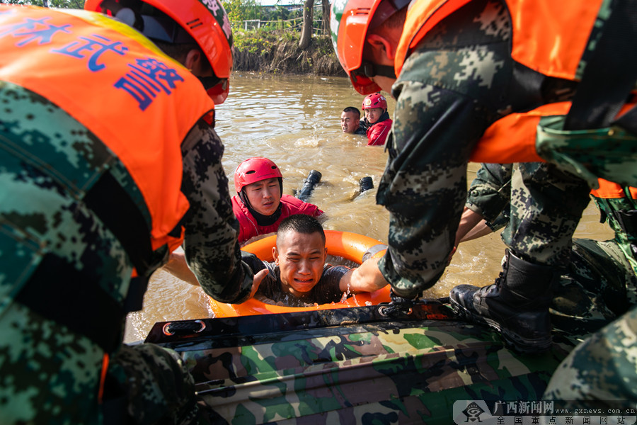 武警官兵和消防队员抢救"受困群众". 广西新闻网通讯员 张宸硕 摄