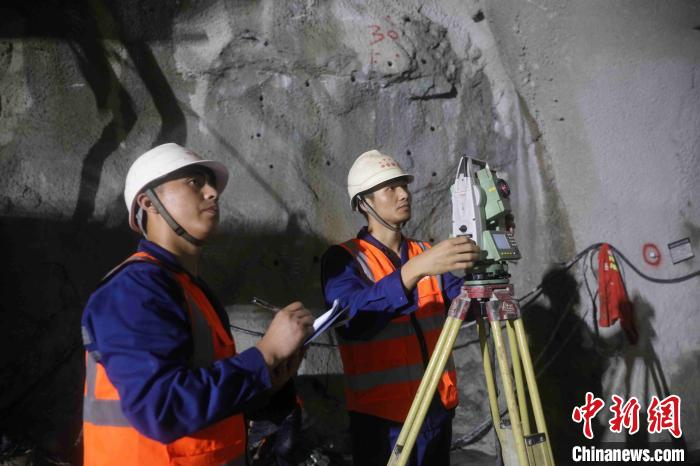 图为中铁隧道局技术人员在高黎贡山隧道1号斜井内监控测量.