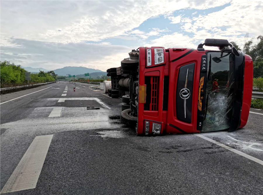 高清组图:贵港一全挂车侧翻漏油 驾驶员被困车内