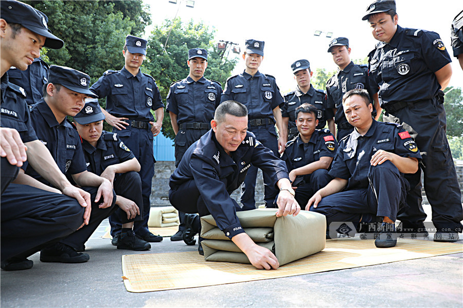 图为特训警"教头"为队员示范叠"豆腐块"被子的方法.