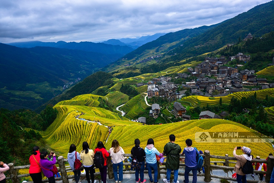 游客在广西桂林市龙胜各族自治县龙脊梯田景区观光游览.
