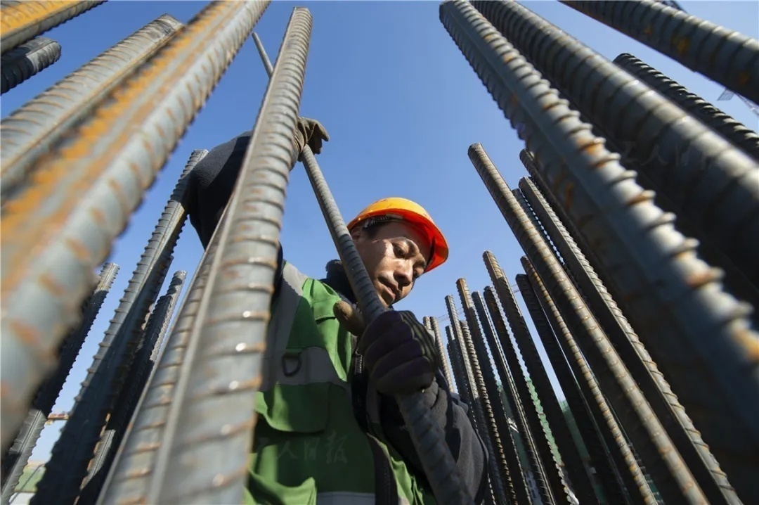 12月4日,钢筋工杨洪在容东片区安置房项目上绑扎立柱.