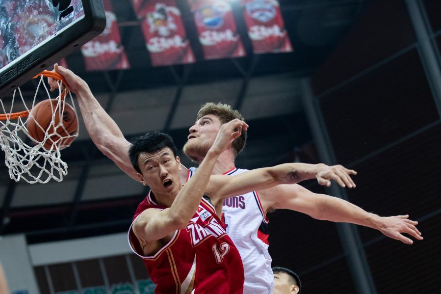 12月27日,时代中国广州队球员哈斯(右)在比赛中扣篮.