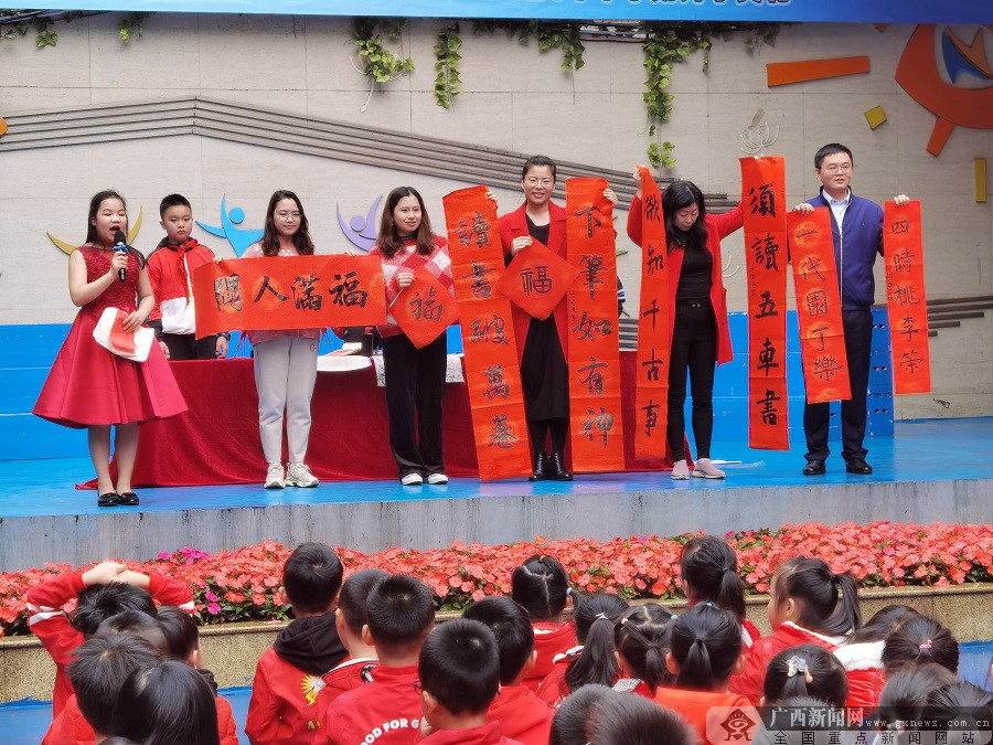 在南宁市南湖小学桃源校区门口,一群活泼可爱的"小牛"们与老师们一齐