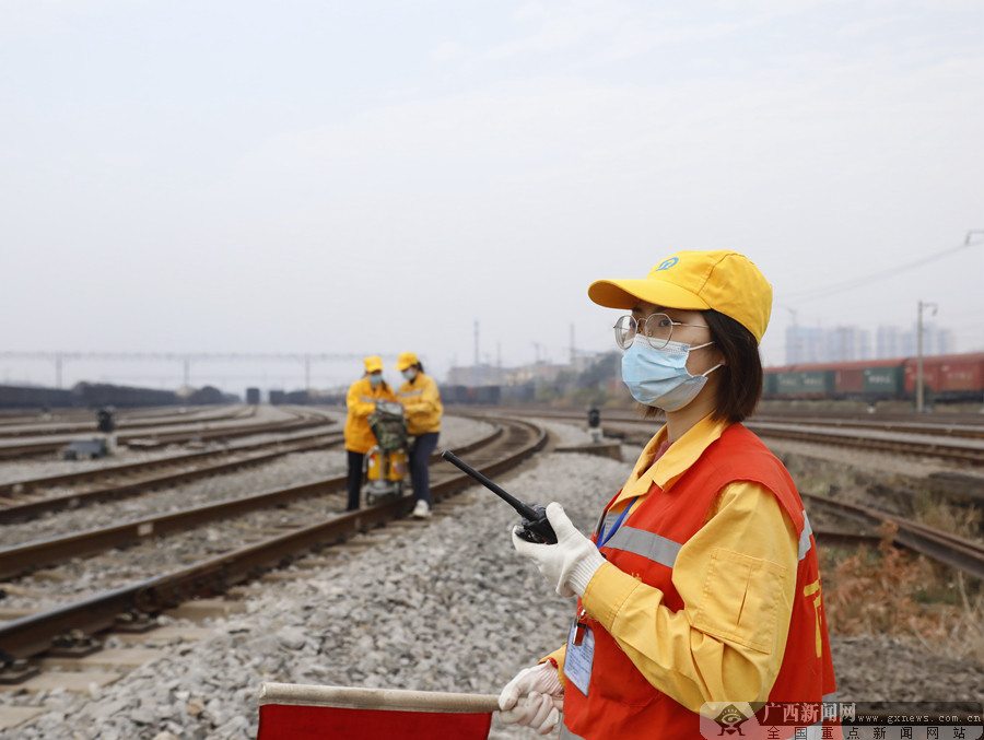 女子探伤班防护员谭宁用对讲机与驻站联络员进行联系,确保现场作业