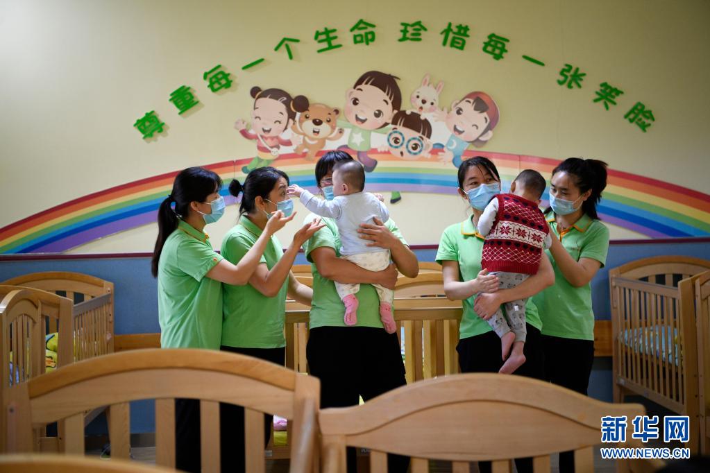 宁夏儿童福利院从事幼儿护理工作的护工们和孩子在一起(5月8日摄).