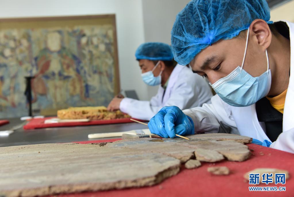 "90后"工作人员纽晓磊在进行壁画修复(5月9日摄)