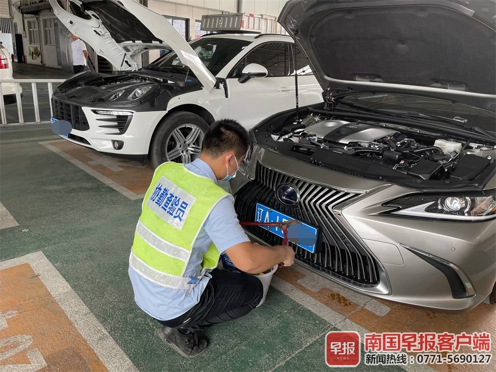 查验员正在拆下二手小车的原车牌号.